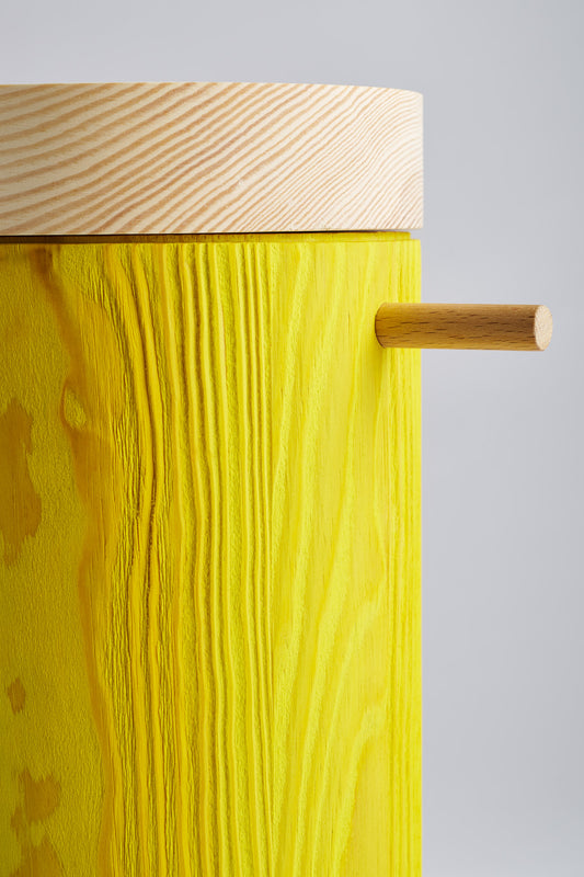 Close up of bright yellow colored wooden urn