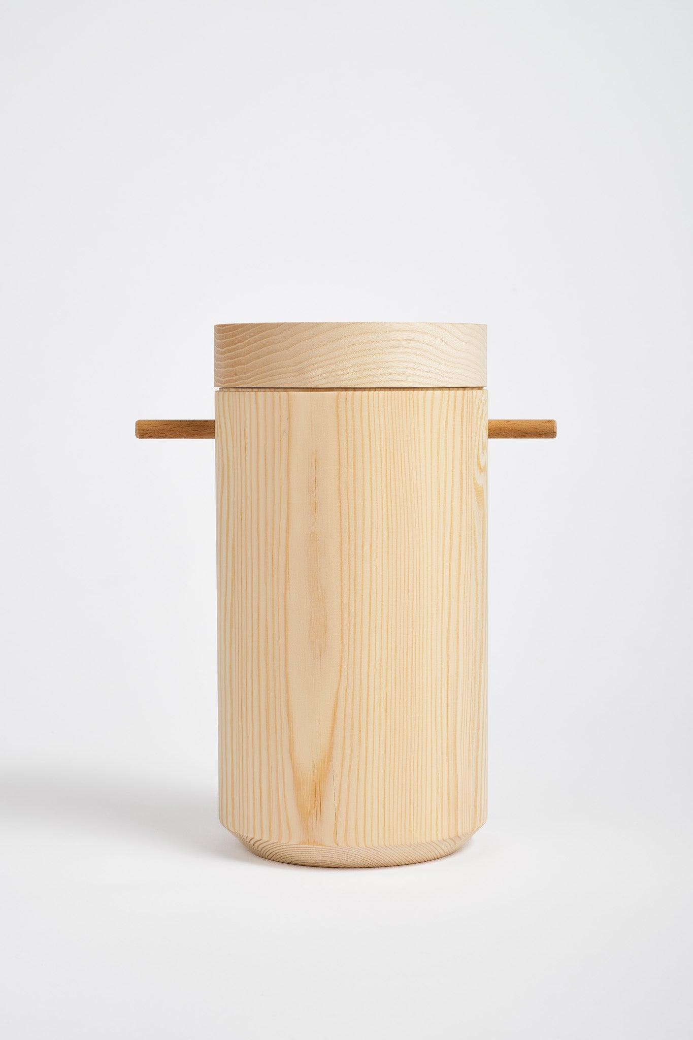 Cylinder shaped, wooden urn ion a white bckground