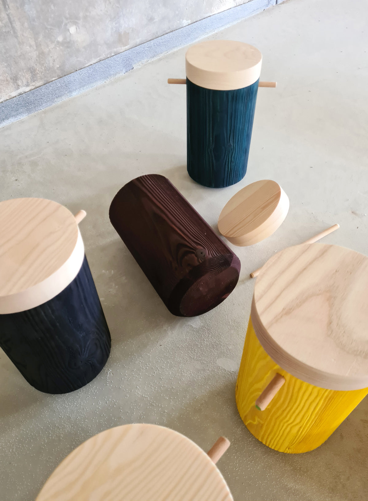 Collection of different colors urn displayed loosely on a concreate floor