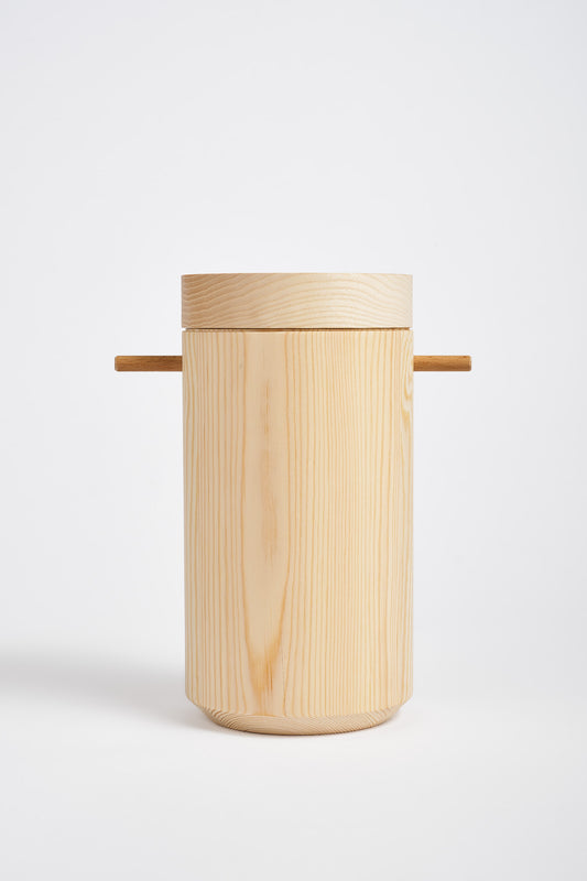 Cylinder shaped, wooden urn ion a white bckground