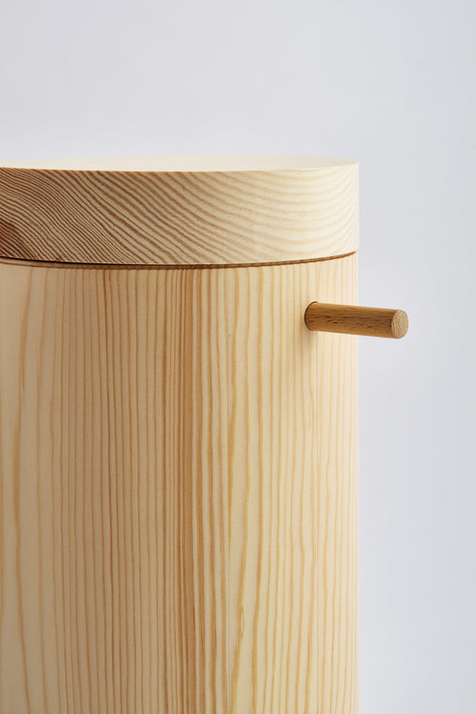 Close up of cylinder shaped, wooden urn 