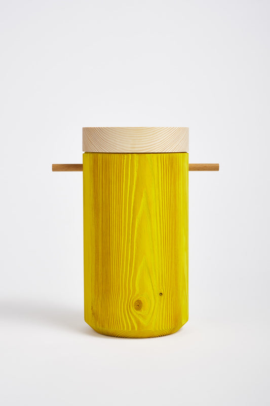 Bright yellow colored wooden urn photographed in studio